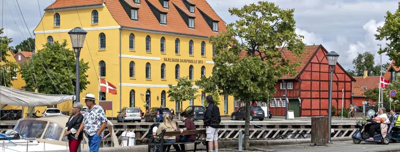 Le moulin à vapeur jaune de Skælskør au bord du port, bateaux au premier plan