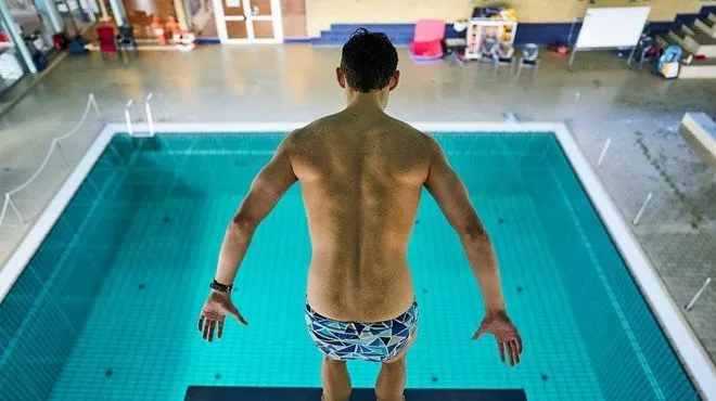 Nageur sur le plongeoir au-dessus du bassin couvert de la piscine de Slagelse